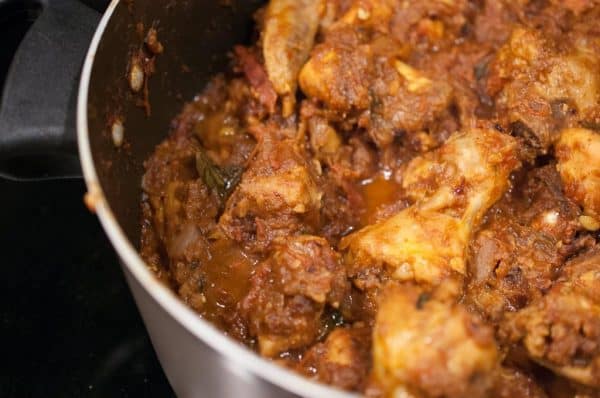 Marinated chicken cooking in a rich semi-gravy for Nadan Chicken Roast.