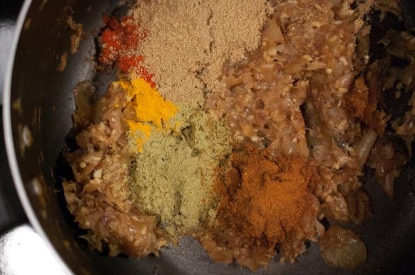 Ground spices, including chilli, coriander, fennel, and garam masala powder added to the onion masala for Chicken Roast.
