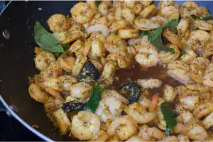 Prawns being sautéed with curry leaves and spices for Kerala Style Chemmeen Roast.