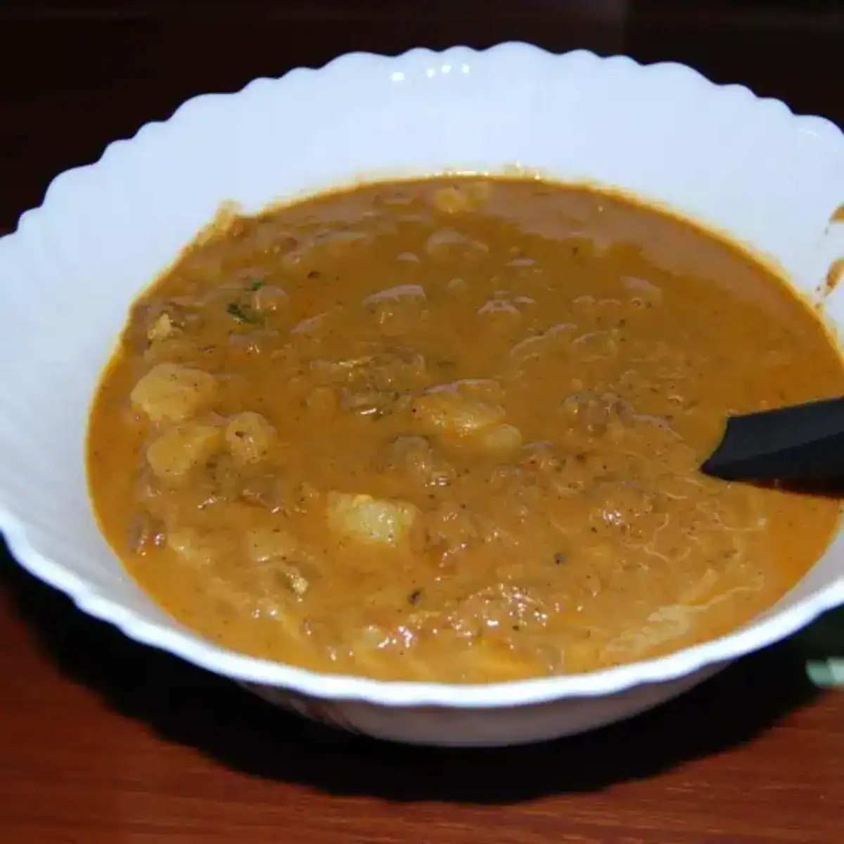 Kerala style beef curry with potato served in a white bowl, showing thick coconut-based gravy with beef and potato pieces.
