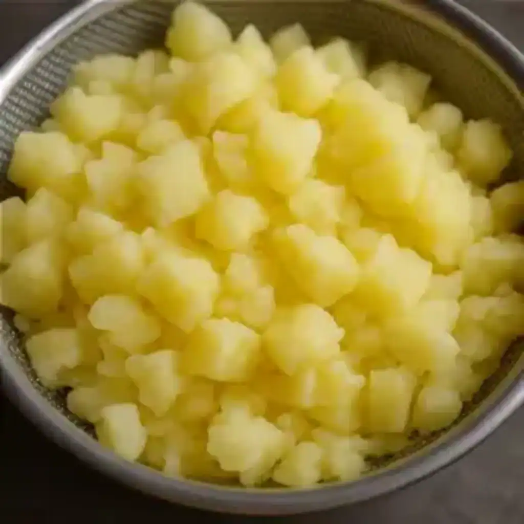 Cooked tapioca pieces drained and placed in a steel strainer.