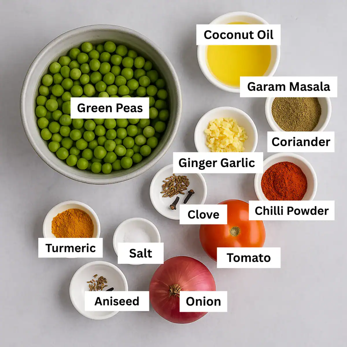 Ingredients for Kerala style green peas masala curry arranged in bowls on a grey background, including peas, spices, onion, tomato, garlic, ginger, and coconut oil.