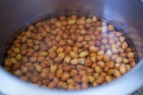 Soaked brown chickpeas transferred to a pressure cooker.