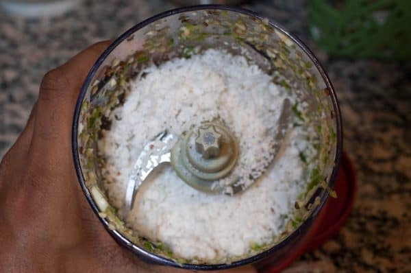 Grated coconut, green chilies, and garlic in a blender jar.