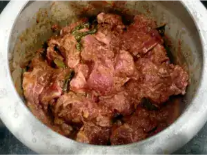 Bone-in mutton is coated with masala in the cooker before pressure cooking for mutton curry.