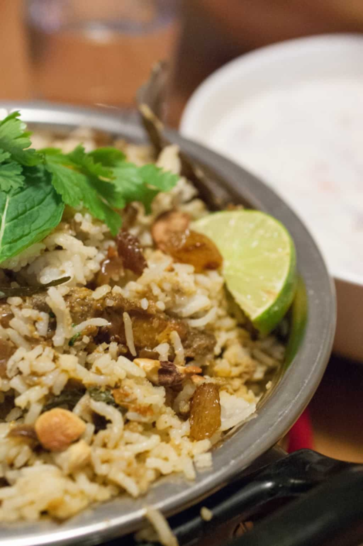 Kerala-style fish biryani served in a bowl, garnished with mint and coriander leaves, along with a lemon wedge.
