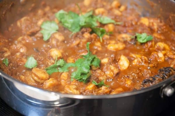 Kerala Style prawns masala simmering in tomato-onion gravy with coriander garnish in a pan