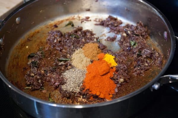 Chilli, turmeric, coriander, and garam masala powders added to onion base for nadan konchu masala.