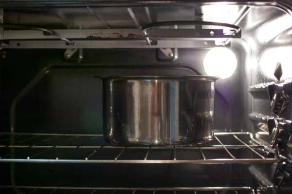 Appam batter kept for fermentation inside a closed oven with light turned on.