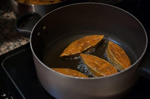 Fish frying in coconut oil until golden brown for Kerala-style fish fry.