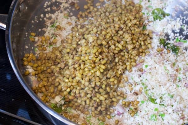 Cooked cherupayar is added to the coconut masala mix in the pan.