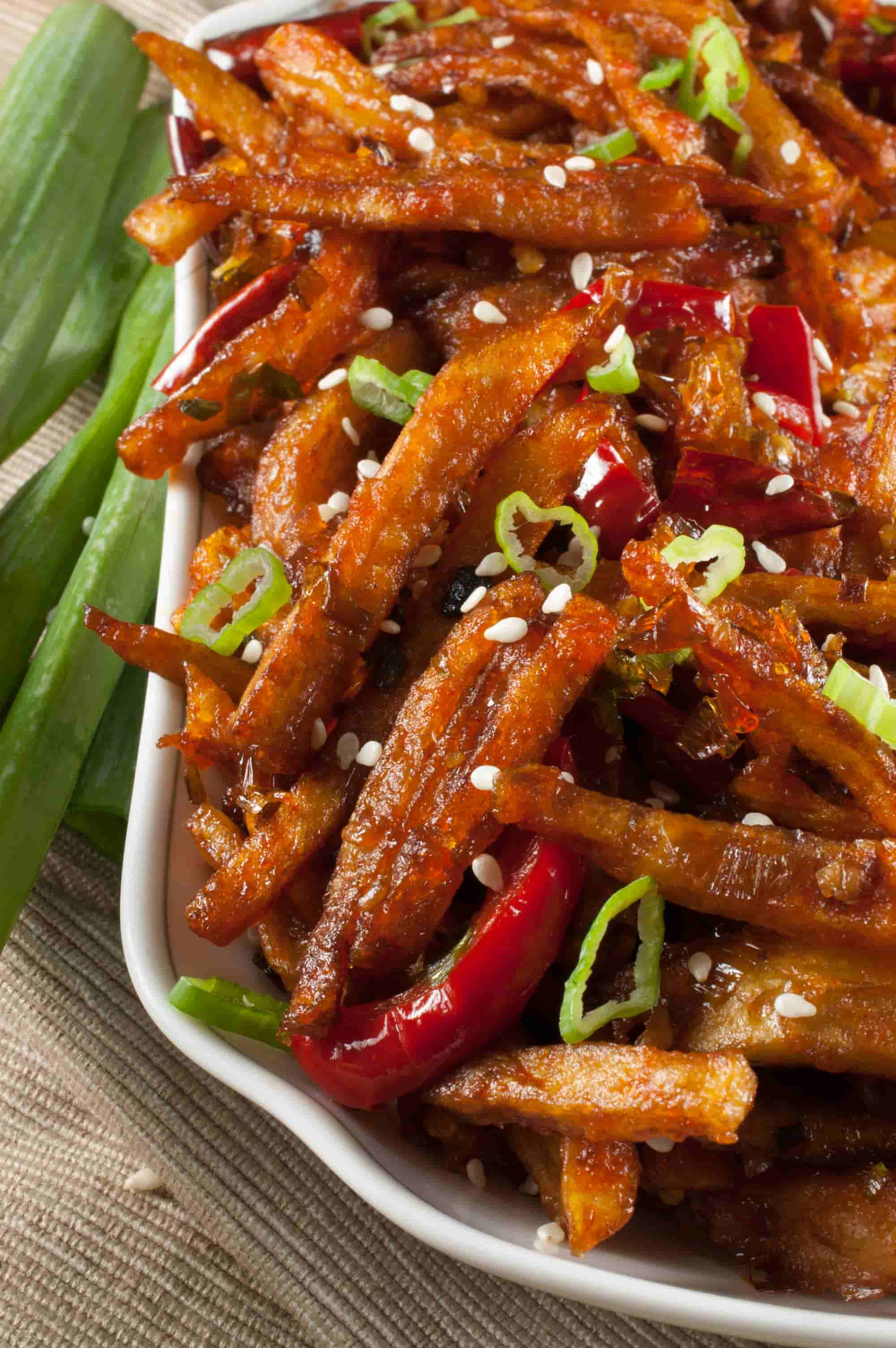 Honey Chilli Potato is a popular Indo-Chinese appetizer. Crispy Fried Potatoes cooked with spring onion and bell peppers in a sweet and spicy sauce.