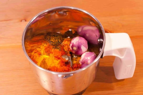 Blender jar with shallots, ginger, garlic, chili, turmeric, lemon juice and pepper for Nadan Netholi Fry.