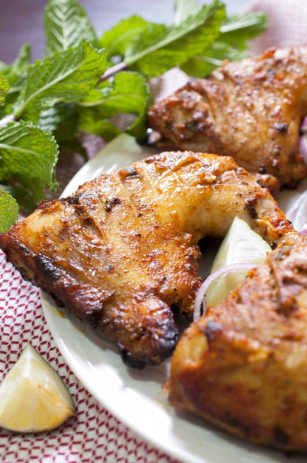 Chicken marinated in yogurt and spices and then baked in an oven. This Indian Tandoori Chicken In Oven recipe is straightforward to make at home with minimal ingredients