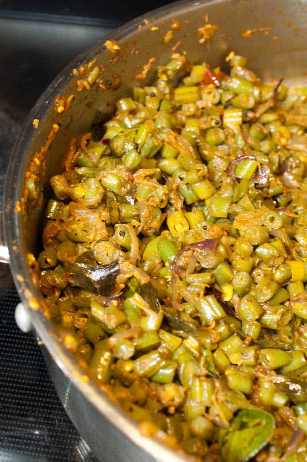 Kerala style beans stir fry with spices, ginger, and garlic. This Beans Mezhukkupuratti or Beans Olathiyathu is a quick and healthy side dish that goes well with rice.