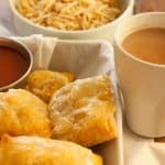 This is an image of Indian style chicken puffs. Tea, tomato ketchup and tapioca chips on the side 