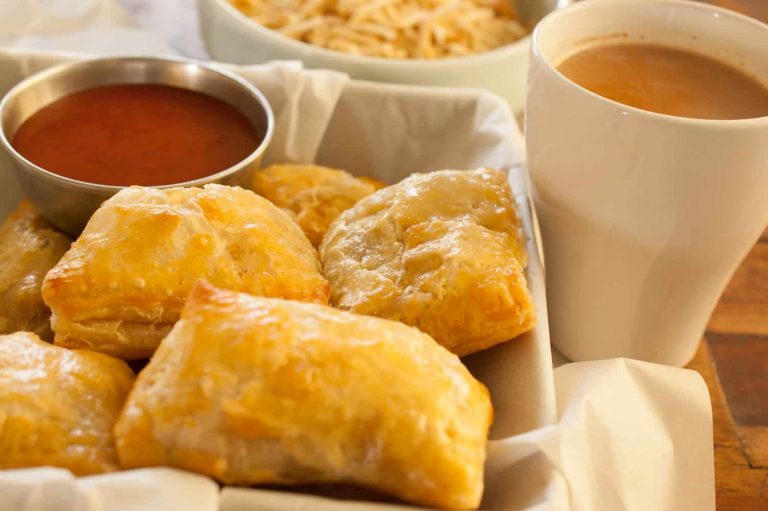 This is an image of indian chicken puffs with tea on the side, ketchup as dipping and some tapioca chips