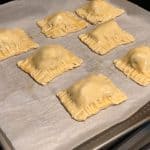 Cut one puff pastry sheet into six equal sized rectangles. Spoon the masala filling into the center of each rectangle piece. Fold the puff pastry sheet. Seal the edges using a fork