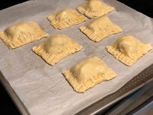 Cut one puff pastry sheet into six equal sized rectangles. Spoon the masala filling into the center of each rectangle piece. Fold the puff pastry sheet. Seal the edges using a fork
