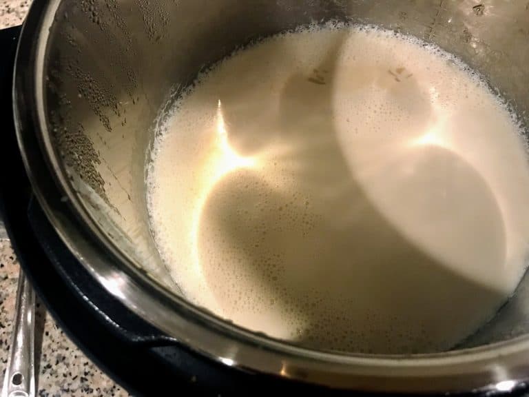 Add the roasted ada into boiling milk. Close the pressure cooker lid