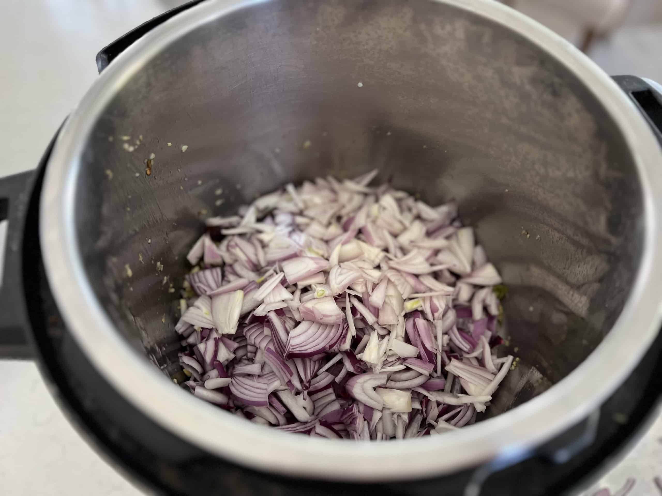 Fry sliced onion and shallots in coconut oil